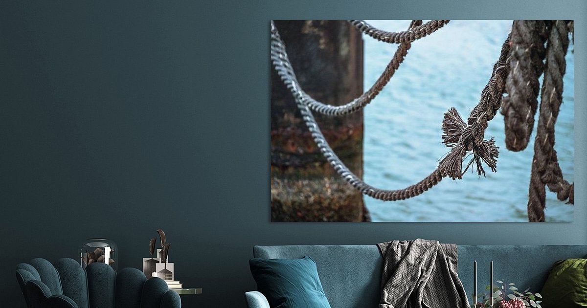 Knoop aan een oud scheepstouw op een steiger over het water, metafoor